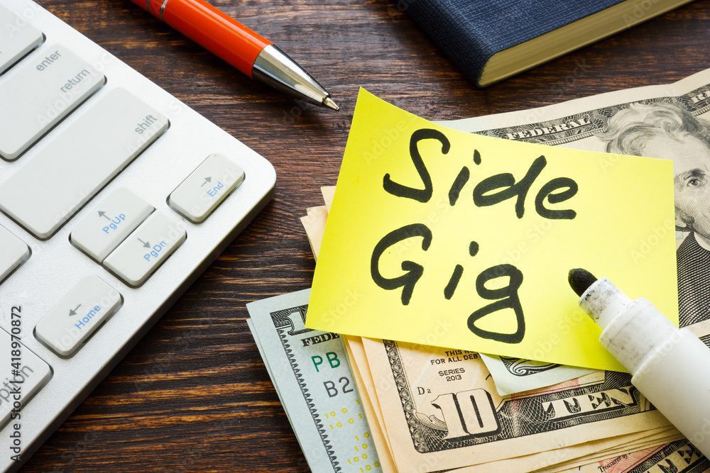 Money from side gig and keyboard on the desk.