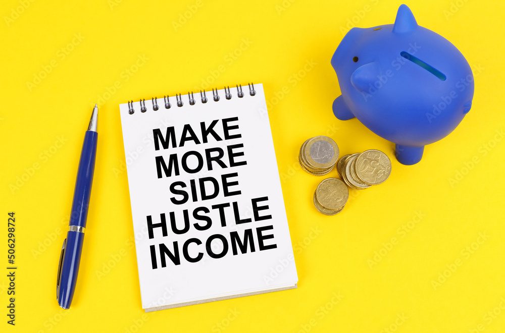 On a yellow surface, a piggy bank, coins and a notepad with the inscription - Make more side hustle income